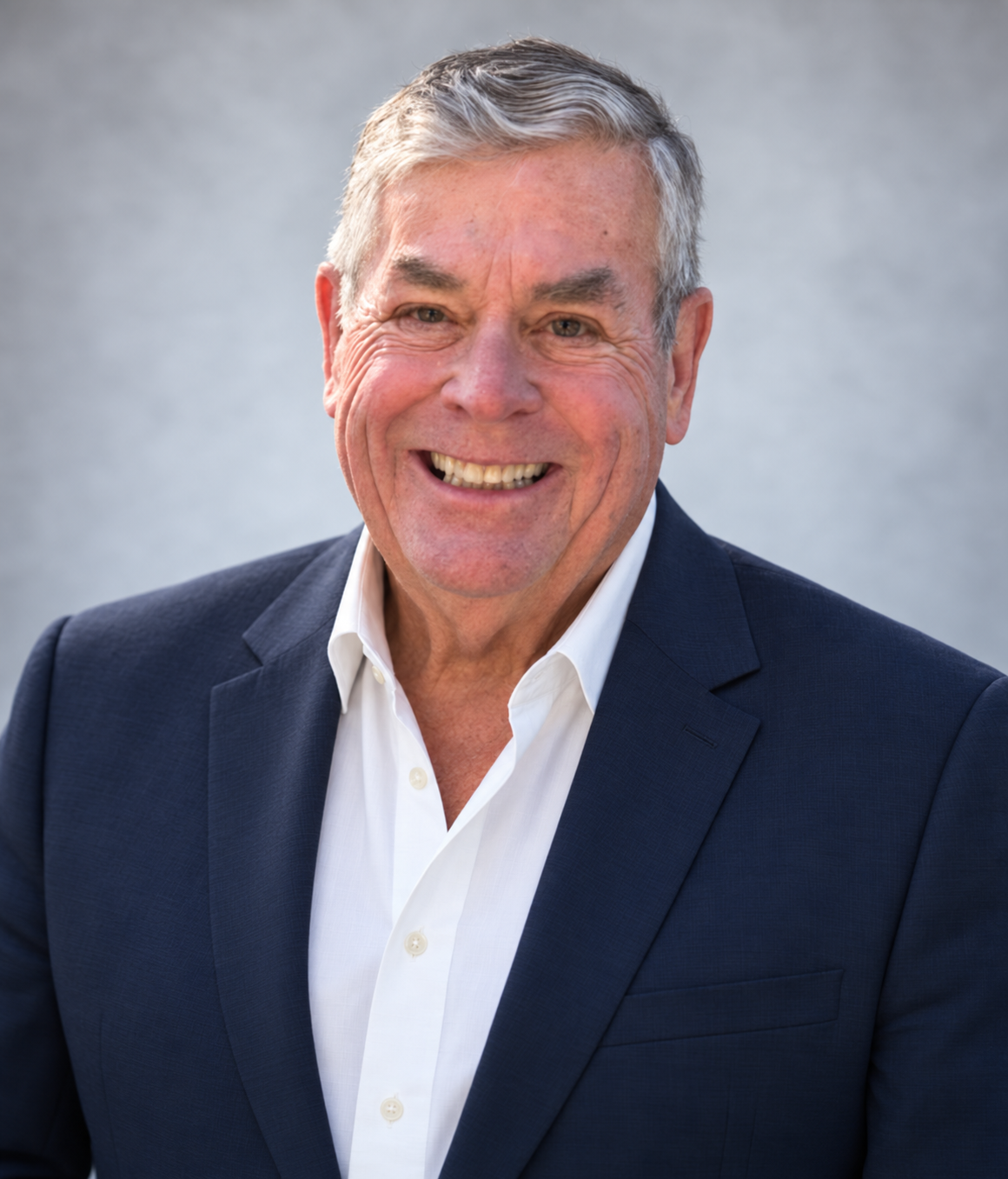 John Magee smiling in a navy blazer